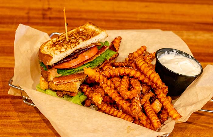 Delicious and satisfying blt sandwich served with sweet potato fries by Wurst Bier Hall in West Fargo ND.