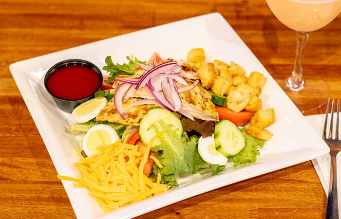 Refreshing chargrilled chicken salad served by Wurst Bier Hall in West Fargo ND.