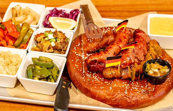 Giant Bavarian pretzel served with sausages and various toppings at Wurst Bier Hall in West Fargo ND.