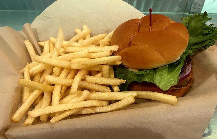 Wurst Beer Hall lunch burger basket topped with American cheese, tomato, lettuce, onion, pickle & haus sauce